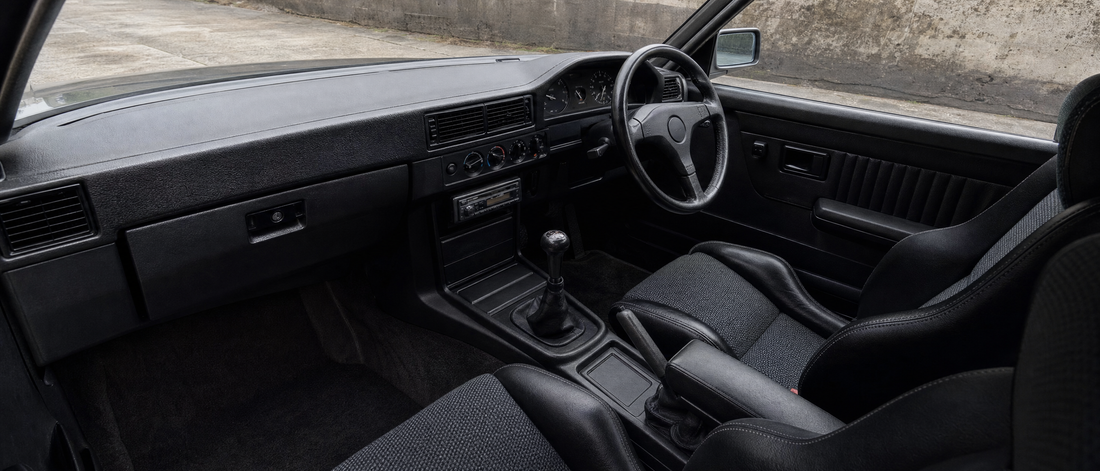 Dark 1990s sports saloon interior with cloth bucket seats