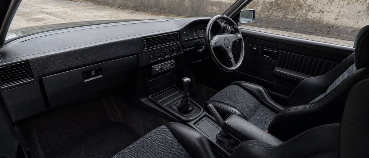 Dark 1990s sports saloon interior with cloth bucket seats