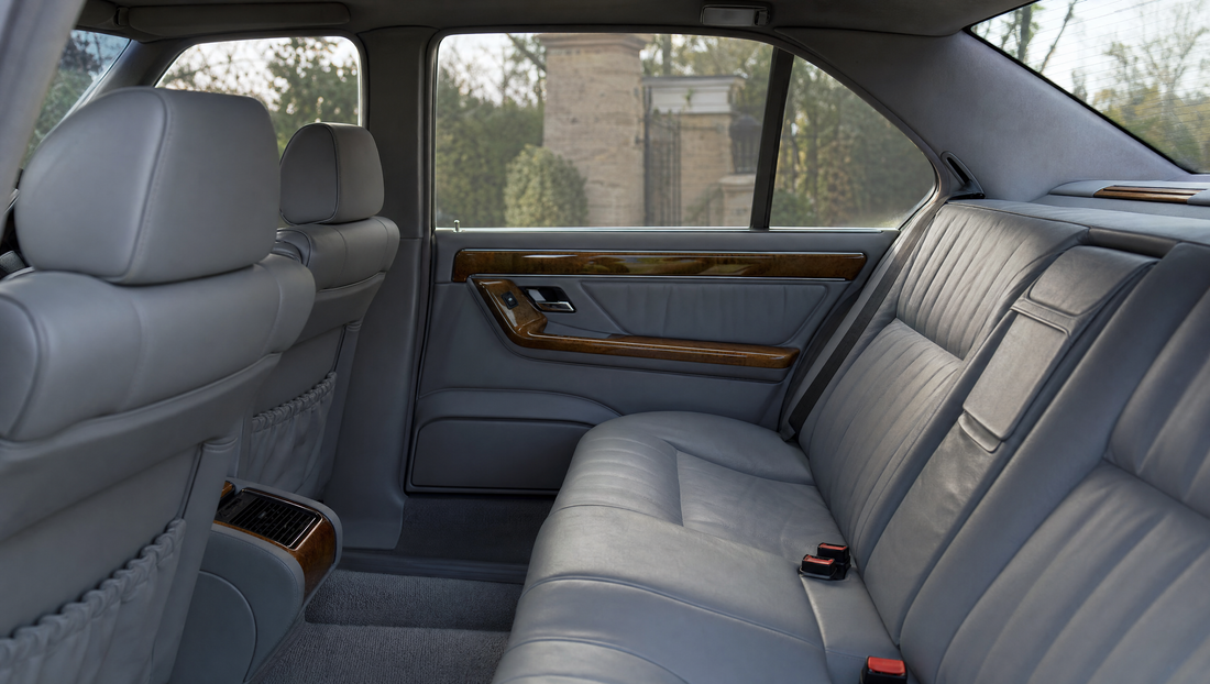 Rear cabin of a 1990s executive saloon with grey leather and wood trim