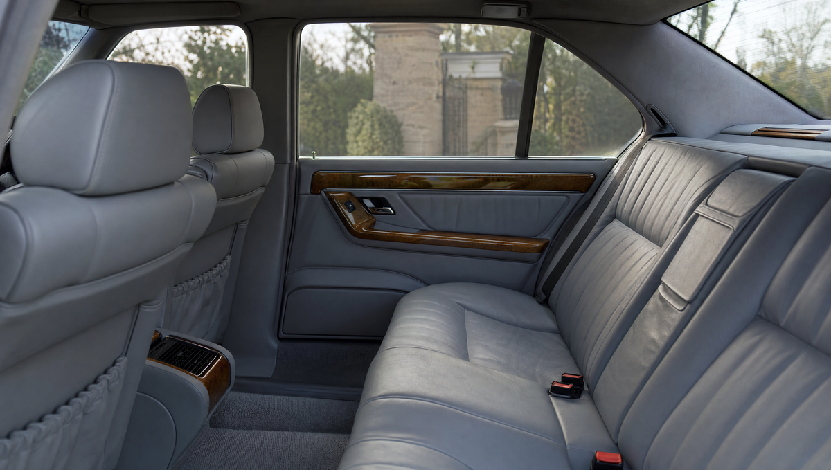 Rear cabin of a 1990s executive saloon with grey leather and wood trim